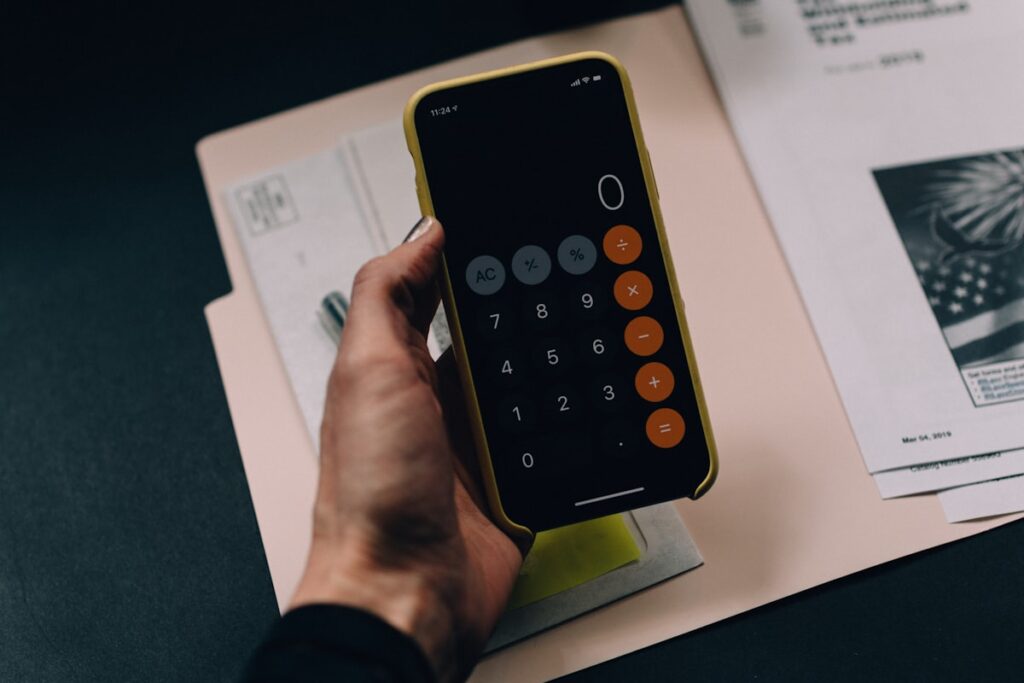 Documentos y calculadora para organizar los costos de una empresa